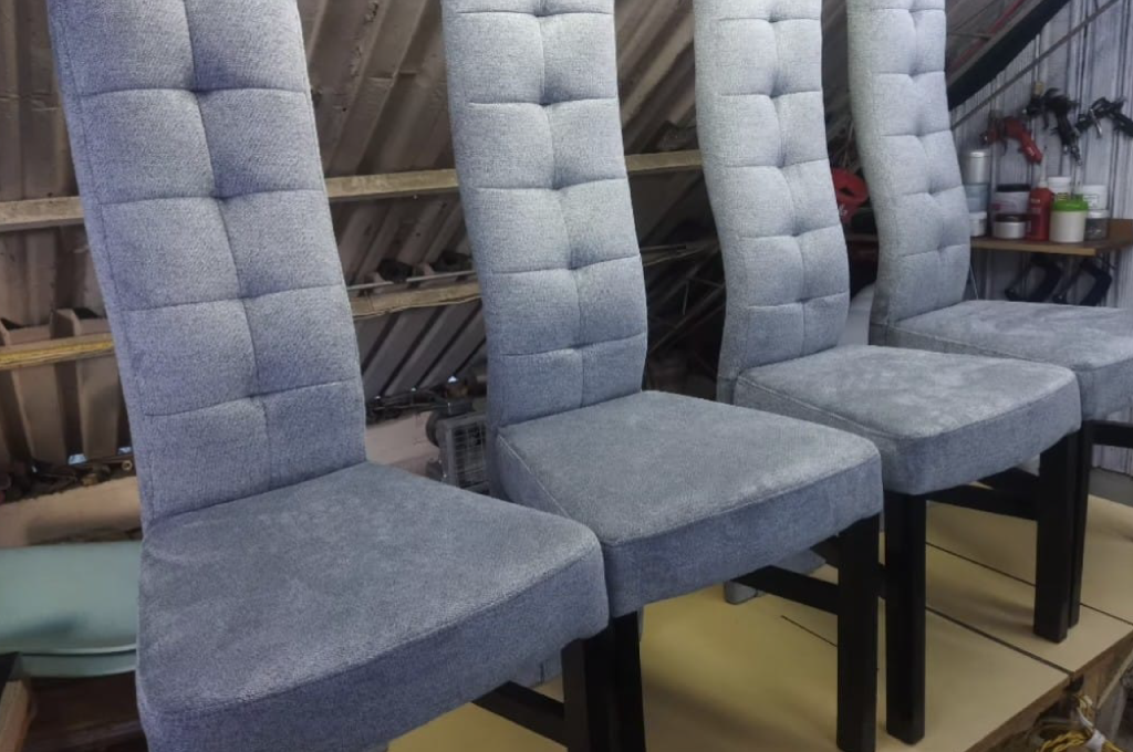 Conjunto de sillas tapizadas en tela azul con pequeño respaldo en capitoné