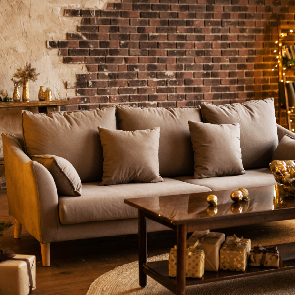 Sofá tapizado con tela beige y cojines propuestos por tapicería centro en Alcalá de Henares