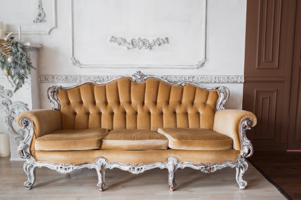 Sofá Clasico con respaldo en terciopelo marrón. Acabados en madera pintada de color plata